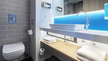 A modern bathroom with a white toilet, a sink with a blue-lit mirror, and a towel rack.