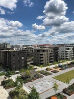 Um complexo de apartamentos moderno com vários edifícios, área de estacionamento e jardins ajardinados.