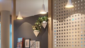 A modern interior with pendant lighting, a wall-mounted plant, and framed artwork.