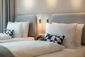 Ropa de cama hipoalergénica y caja de seguridad en la habitación 