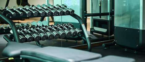 A gym with a bench and a rack of dumbbells.