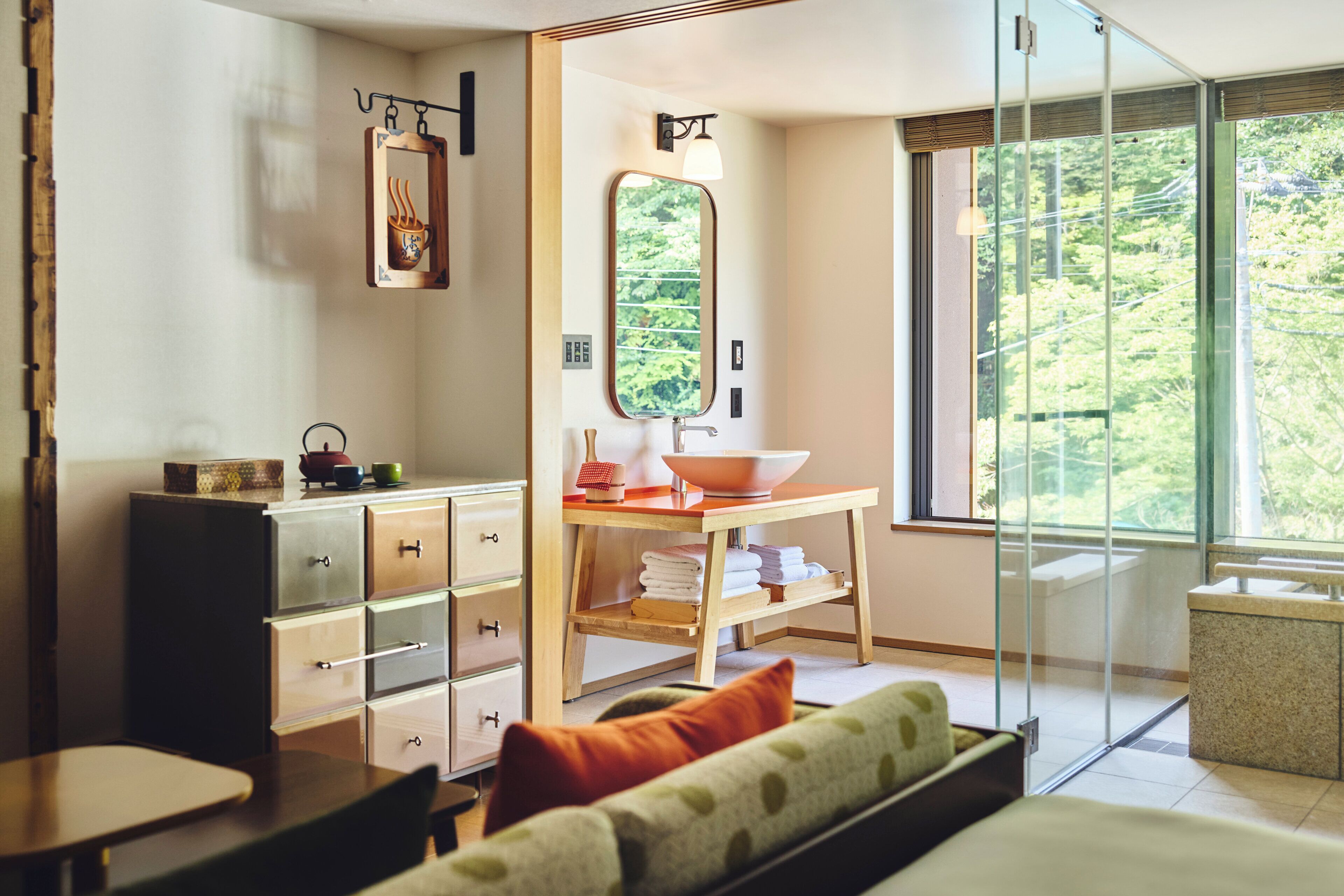 A modern bathroom with a glass shower enclosure, a wooden vanity with a bowl sink, and a large mirror.