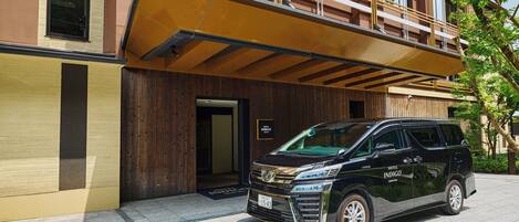 A black SUV parked in front of a building with a wooden facade and a sign that reads "HOTEL INDIGO."