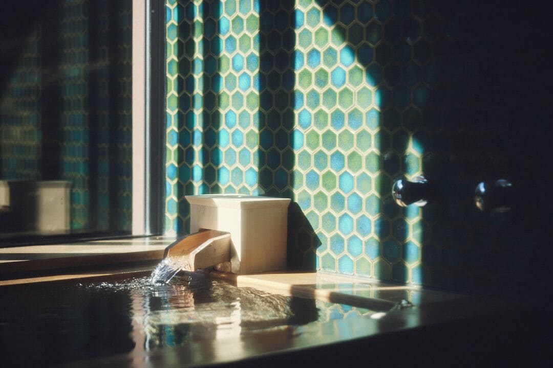 A bathtub with a wooden side, a white soap dish, and a faucet.