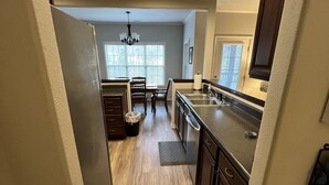 A kitchen with wooden cabinets, a dining table, and a chandelier.