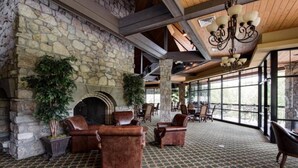A spacious lobby with a stone fireplace, leather sofas, and a patterned carpet.