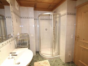 Un bagno con doccia, lavandino e specchio.