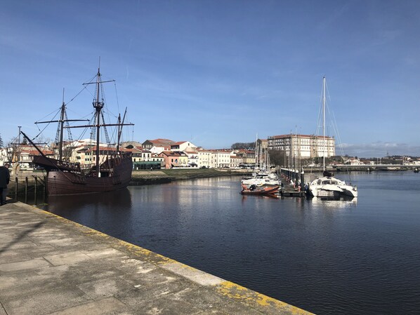 A harbor with a large ship docked, smaller boats, and buildings along the waterfront. - Very nice sea view apartment (Vila do Conde)