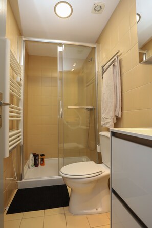 A bathroom with a glass-enclosed shower, a toilet, and a sink. - Very nice sea view apartment (Vila do Conde)