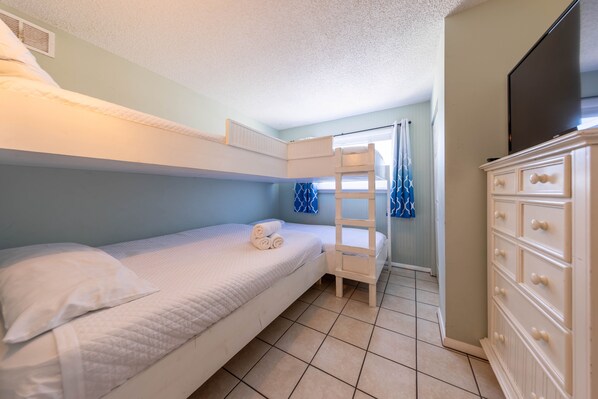 A bunk bed room with a dresser and a television. - Summit 2BR 2BA 13th Floor End Unit w/ BEACH CHAIRS INCL!!! (Panama City Beach)