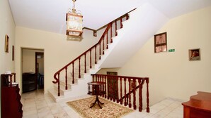 A spacious room with a grand staircase, a chandelier, and a patterned rug. - Villas Quinta da Lapa 2. Villa. Heated pool. WiFi (Câmara de Lobos)