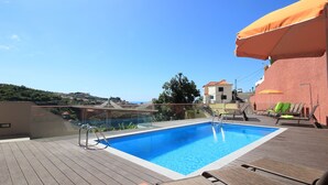 A rooftop swimming pool with a clear view of the surrounding landscape, including hills and a distant building. - Villas Quinta da Lapa 2. Villa. Heated pool. WiFi (Câmara de Lobos)