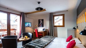 Une chambre d’hôtel équipée d’un lit, d’un bureau, d’une chaise, d’une petite table avec le petit-déjeuner et d’une télévision.