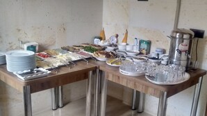 A buffet setup with various food items and utensils.