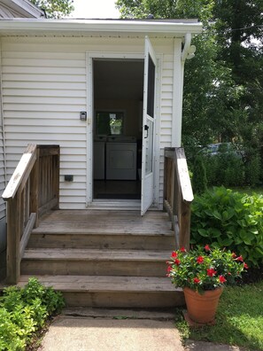 Step into this charming home, featuring a cozy porch with a welcoming entrance and a glimpse of the interior kitchen area.