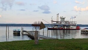 Un lago con un molo e una grande barca chiamata 'Gartenhaus Belle'.