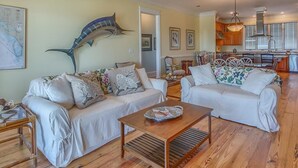 A spacious living room with two white sofas, a wooden coffee table, and a large decorative fish mounted on the wall. - Old Florida, View of St Vincent's Island, Near Boat Landing ~ Island Idyl (Indian Pass)