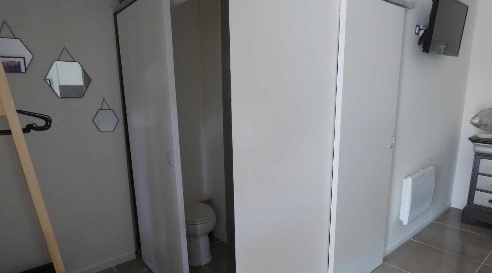 A bathroom with a toilet, a mirror, and a towel rack.