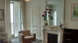 Un salon avec un canapé, une cheminée et un grand miroir.