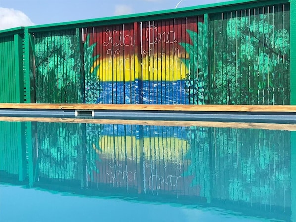 Una piscina al aire libre, sillones reclinables de piscina