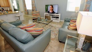 A living room with a sofa, armchairs, a glass coffee table, and a television. - New Listing! Compass Bay Resort, 3mi to Disney & 9mi to Universal - IT3006 (Kissimmee)