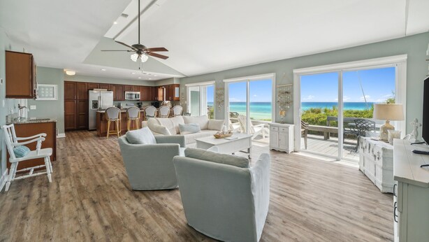 Een ruime woonkamer met keuken, eethoek en balkon met uitzicht op zee.
