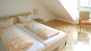 Ein Schlafzimmer mit zwei Betten, einem Nachttisch, einer Lampe und einem Stuhl.