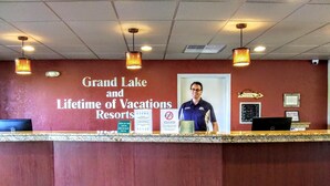 Mostrador de recepción en Grand Lake y Lifetime of Vacations Resorts, con un letrero, una computadora y una cámara de seguridad.