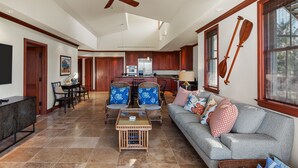 A spacious living area with a sofa, chairs, a coffee table, and a ceiling fan.