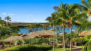 A resort with multiple buildings, palm trees, and a view of the ocean.