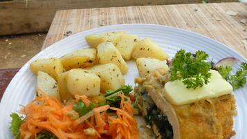 Un plato de comida con papas, ensalada y un trozo de pollo empanizado.