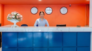 A reception desk with a marble top, blue cabinets, and three wall clocks. - The Poppy Villa & Hotel (Hanoi)