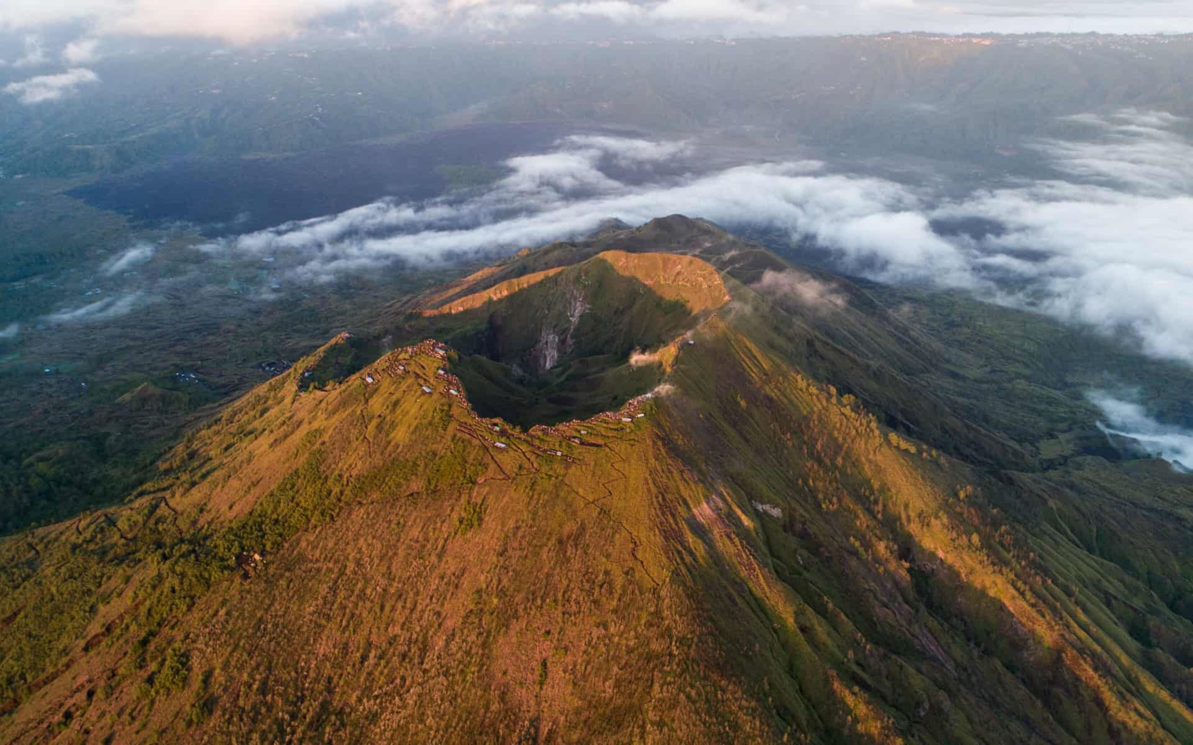 An aerial view of a mountain with a distinct peak and surrounding valleys.