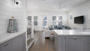 A modern kitchen with white cabinetry, a marble countertop, and a built-in sink.