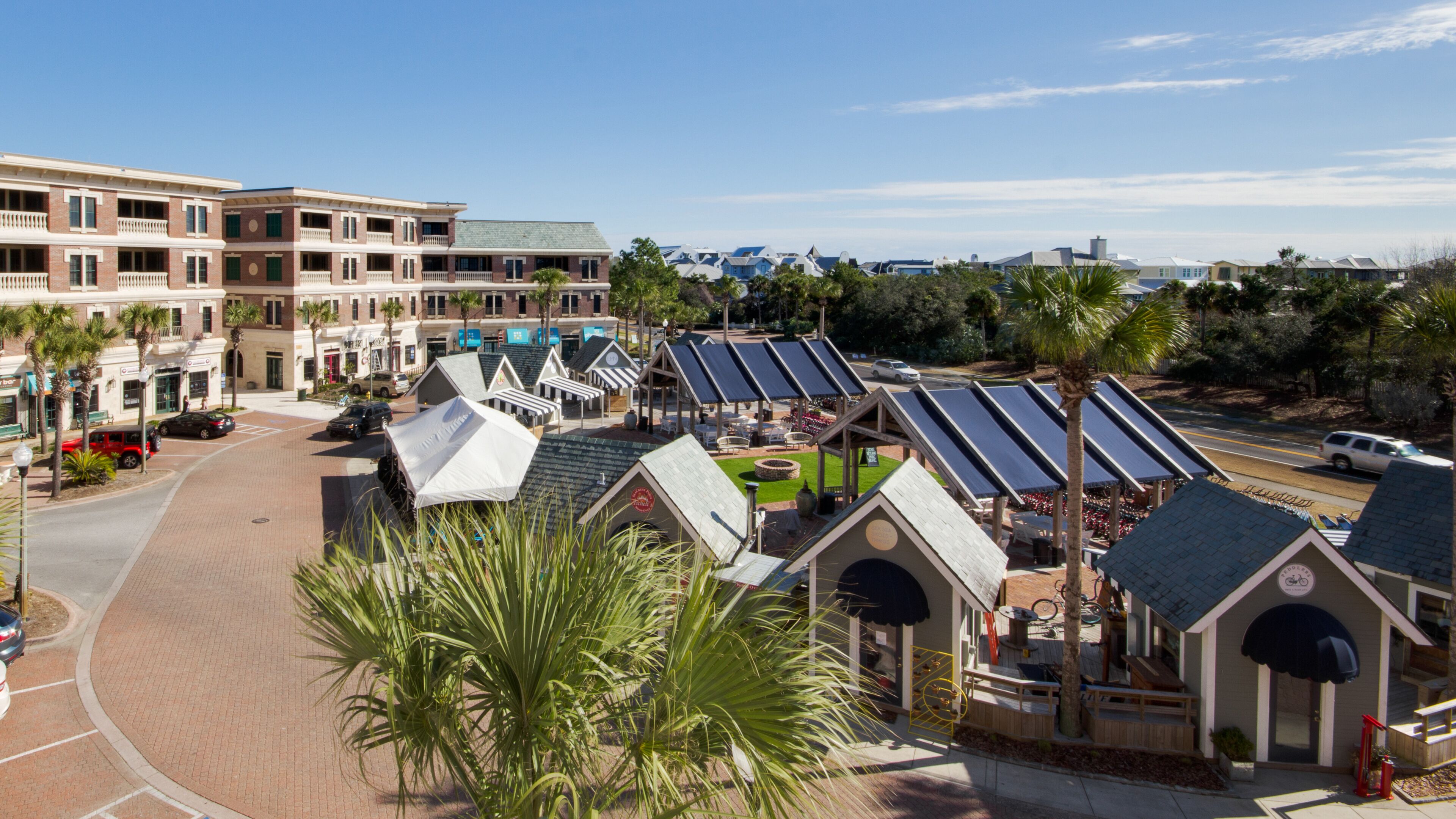 A hotel with multiple-story buildings, a parking area, and a solar-powered outdoor seating area.