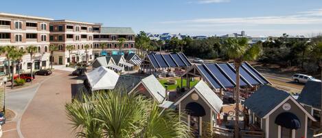 A hotel with multiple-story buildings, a parking area, and a solar-powered outdoor seating area.