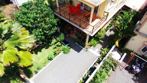 A residential building with a balcony, outdoor seating, and surrounding greenery. - Case Latanier (Grand River South East)