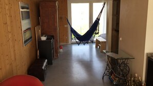 A room with a wooden floor, a hammock, a bench, a table, and a cabinet. - Villino Nacci, in the heart of Tuscany. (San Miniato)