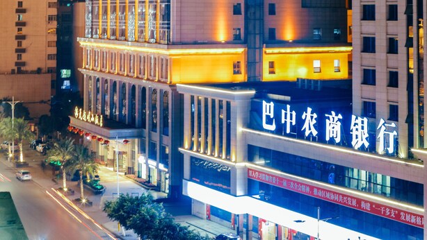 A high-rise building with illuminated signage and a prominent entrance. - Tianyue Minshan Hotel (Bazhong)
