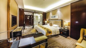 A hotel room with a large bed, bedside tables, a desk, and a chair. - Tianyue Minshan Hotel (Bazhong)