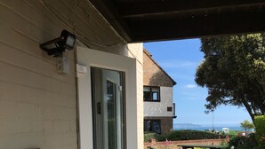 Un bâtiment doté d’une porte en verre qui donne sur un patio aménagé avec une table de pique-nique et une boîte aux lettres.