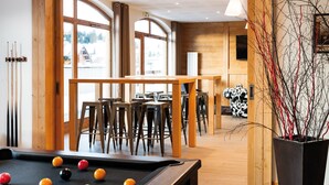 A billiards room with wooden furniture, a pool table, and large windows. - Appart à 100m des Pistes | Accès piscine + Sauna! (Hauteluce)