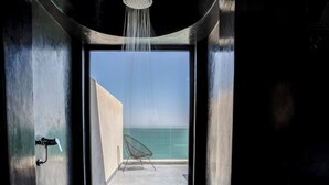 A modern bathroom with a shower, a chair, and a view of the sea. - Palais Rhoul Dakhla (Dakhla)