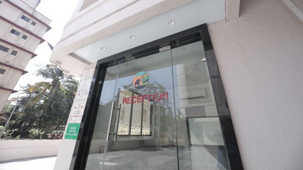 A reception area with a glass door and a sign indicating it is a reception. - The Byke Studio Apartment (Thane)