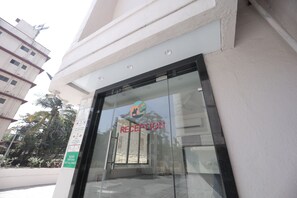 Un área de recepción con puerta de vidrio y un cartel que indica ser recepción.