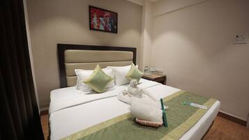 A neatly made bed with a green and white striped bedspread, a headboard, and two pillows.