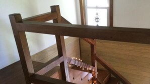 Eine Holztreppe mit Geländer, die zu einer Etage darunter führt.