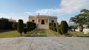 A building with a symmetrical facade, a central entrance, and a paved pathway leading to it.