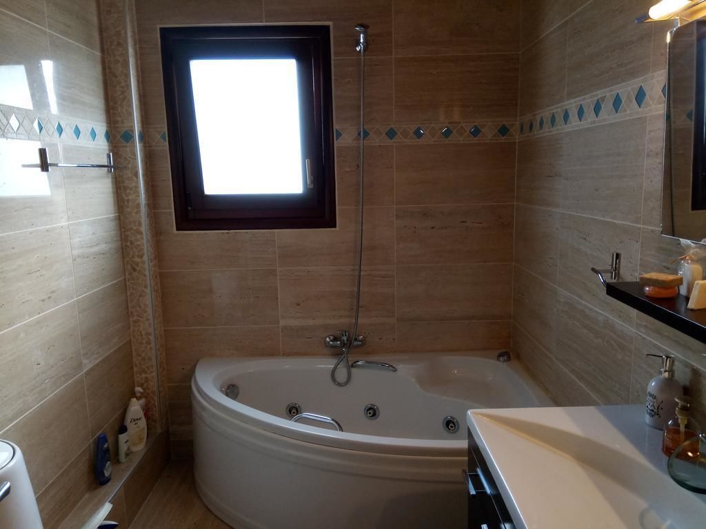 A bathroom with a freestanding bathtub, a window, and a mirror.