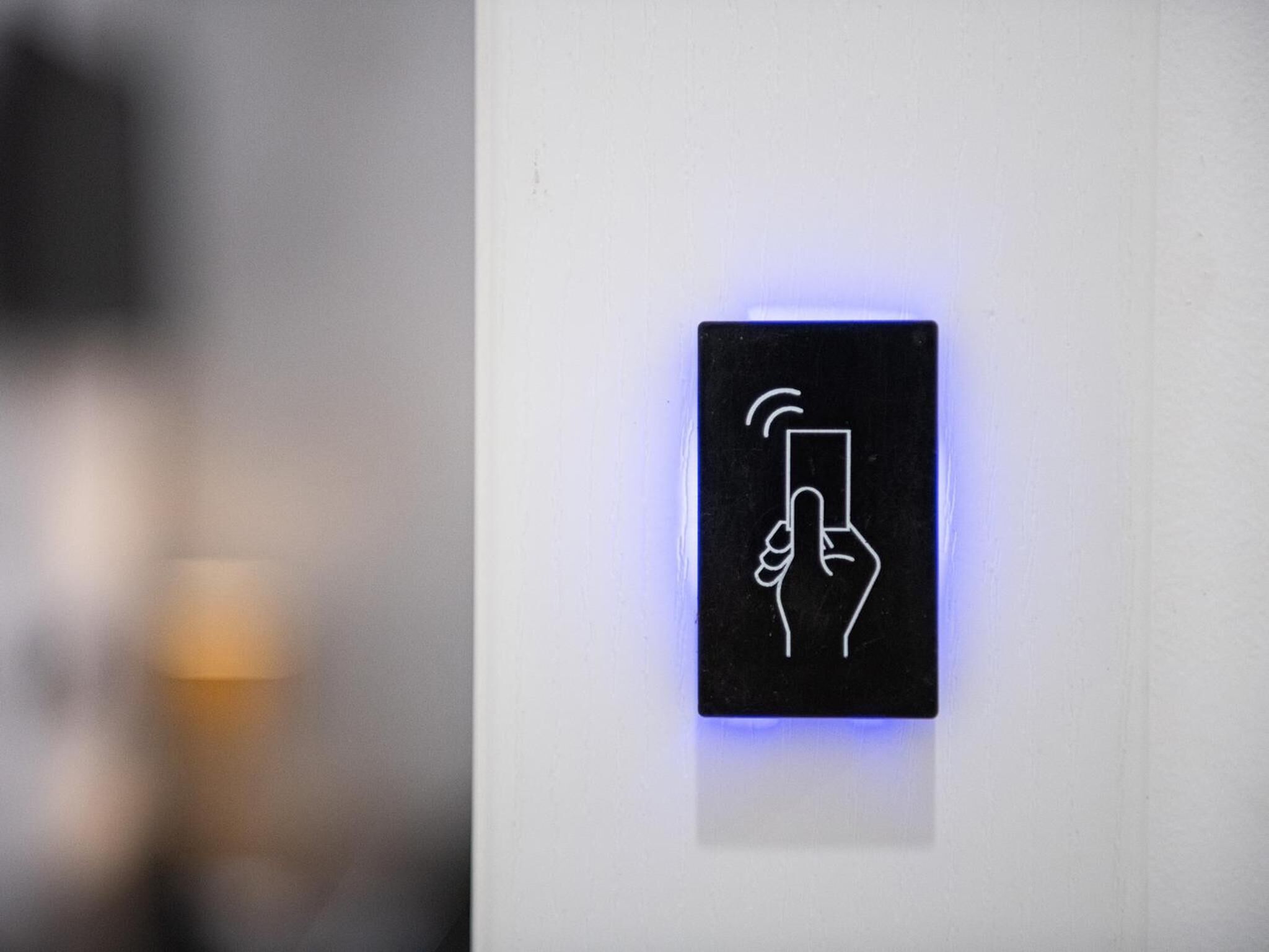A black sign with a hand holding a card, possibly indicating a payment or information point.